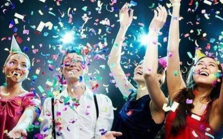 Ausgelassene Menschen während einer Party im Konfettiregen